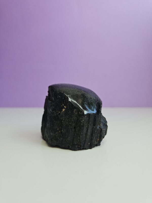 Semipoleret sort turmalin, en kraftfuld beskytter mod negativ energi, der hjælper med at skabe jordforbindelse og skærmer mod stress og angst.