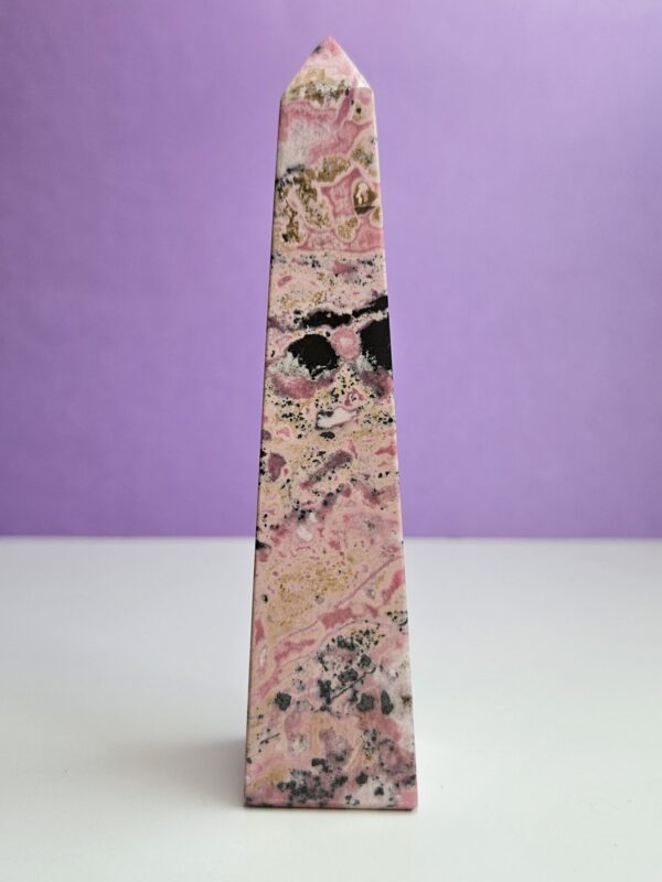 Poleret rhodochrosit tårn, kendt for sin hjerte-healende energi. Denne krystal fremmer kærlighed, medfølelse og følelsesmæssig balance, perfekt til at skabe harmoni i dit liv.