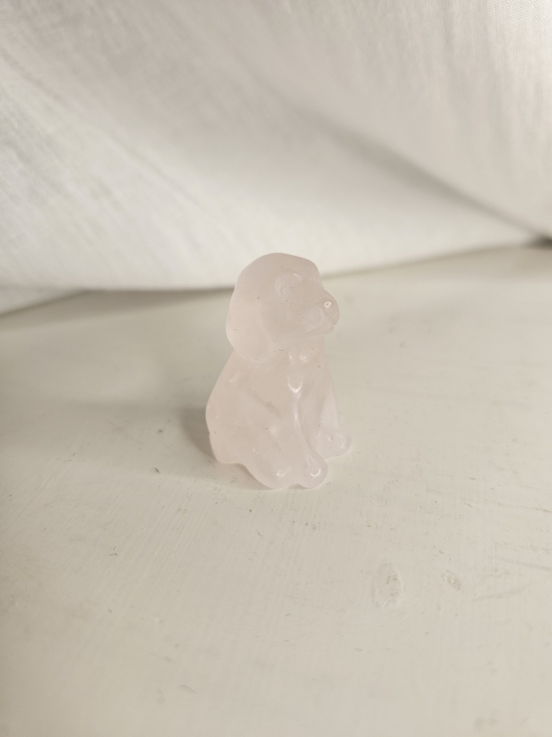 Rosakvarts krystalfigur formet som en hund, kendt for at fremme kærlighed, harmoni og følelsesmæssig heling.