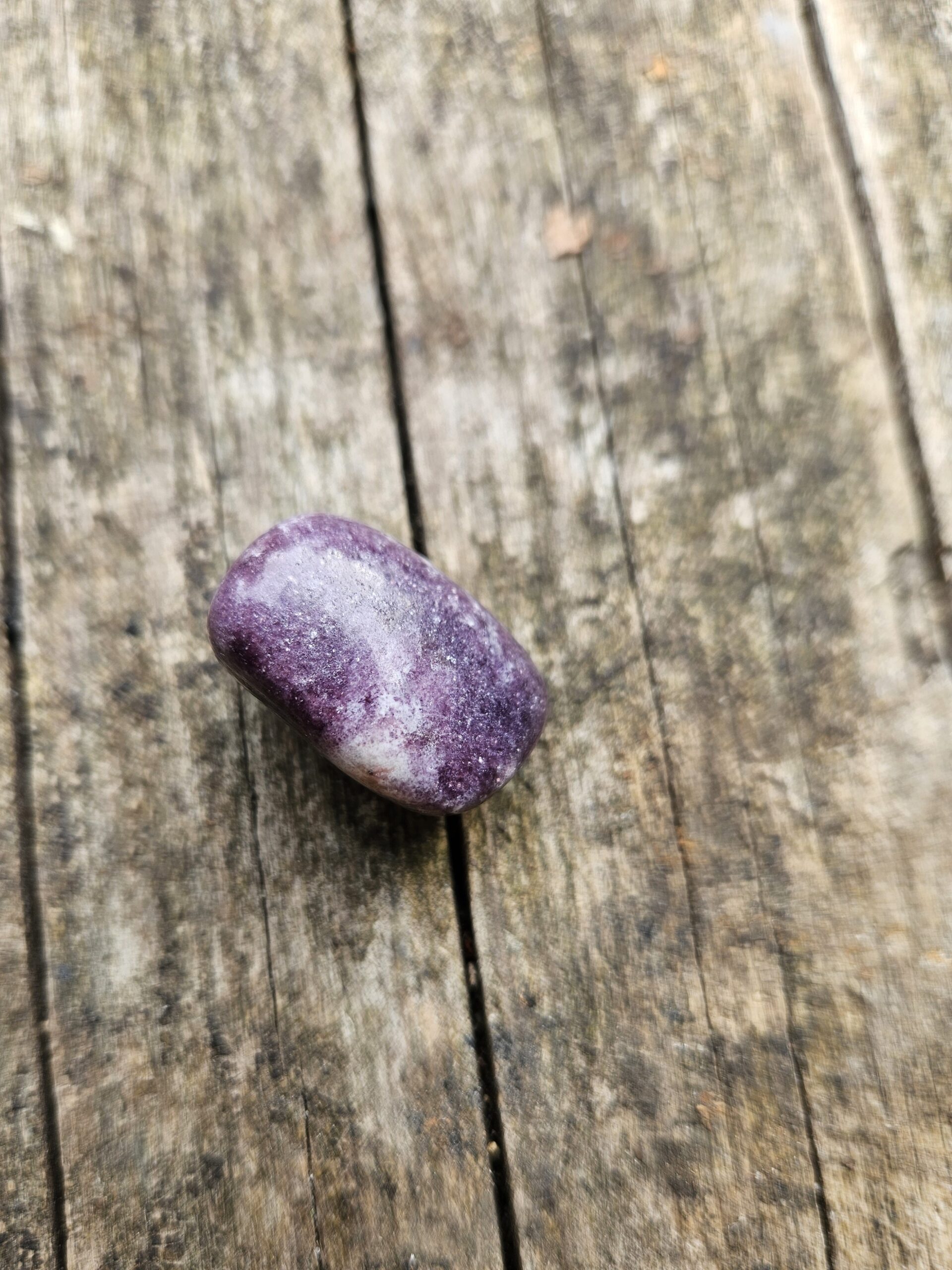 Poleret Lepidolit lommesten, kendt for sin beroligende energi. Denne krystal hjælper med at reducere stress, fremme indre fred, støtte følelsesmæssig balance og forbedre søvnkvaliteten.