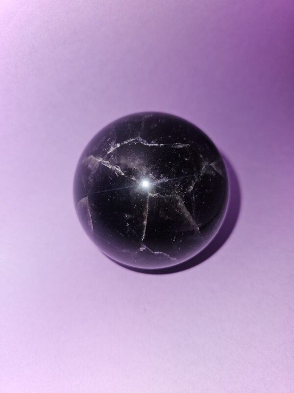 Mørk ametyst kugle, kendt for sine beroligende egenskaber, der fremmer indre ro, åndelig vækst, beskytter mod negative energier og hjælper med at forbedre søvnkvaliteten.