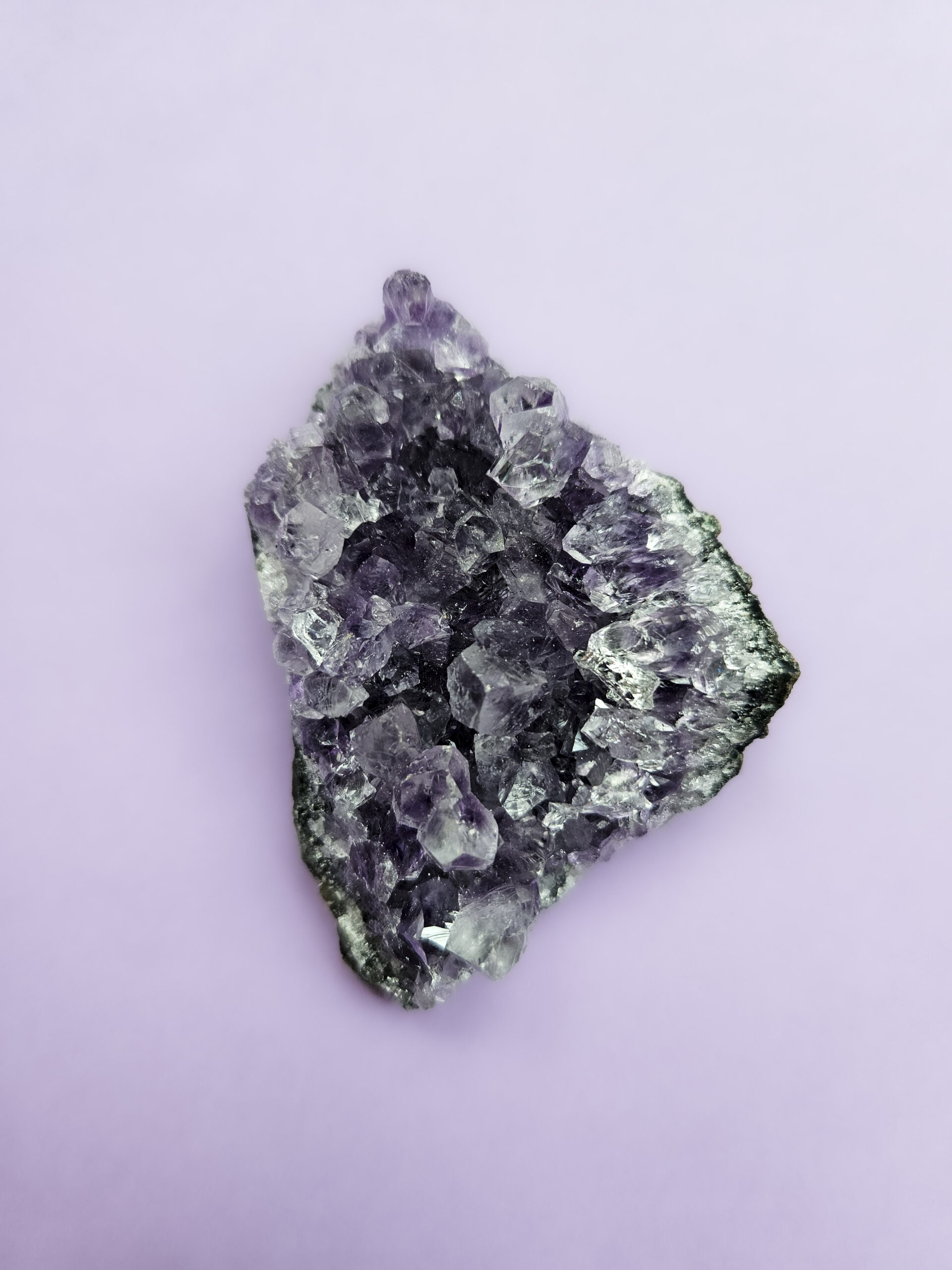 Ametyst klynge, kendt for sine beroligende egenskaber, der fremmer indre ro, åndelig vækst og beskytter mod negative energier. Glimter som en smuk violet stjernehimmel.