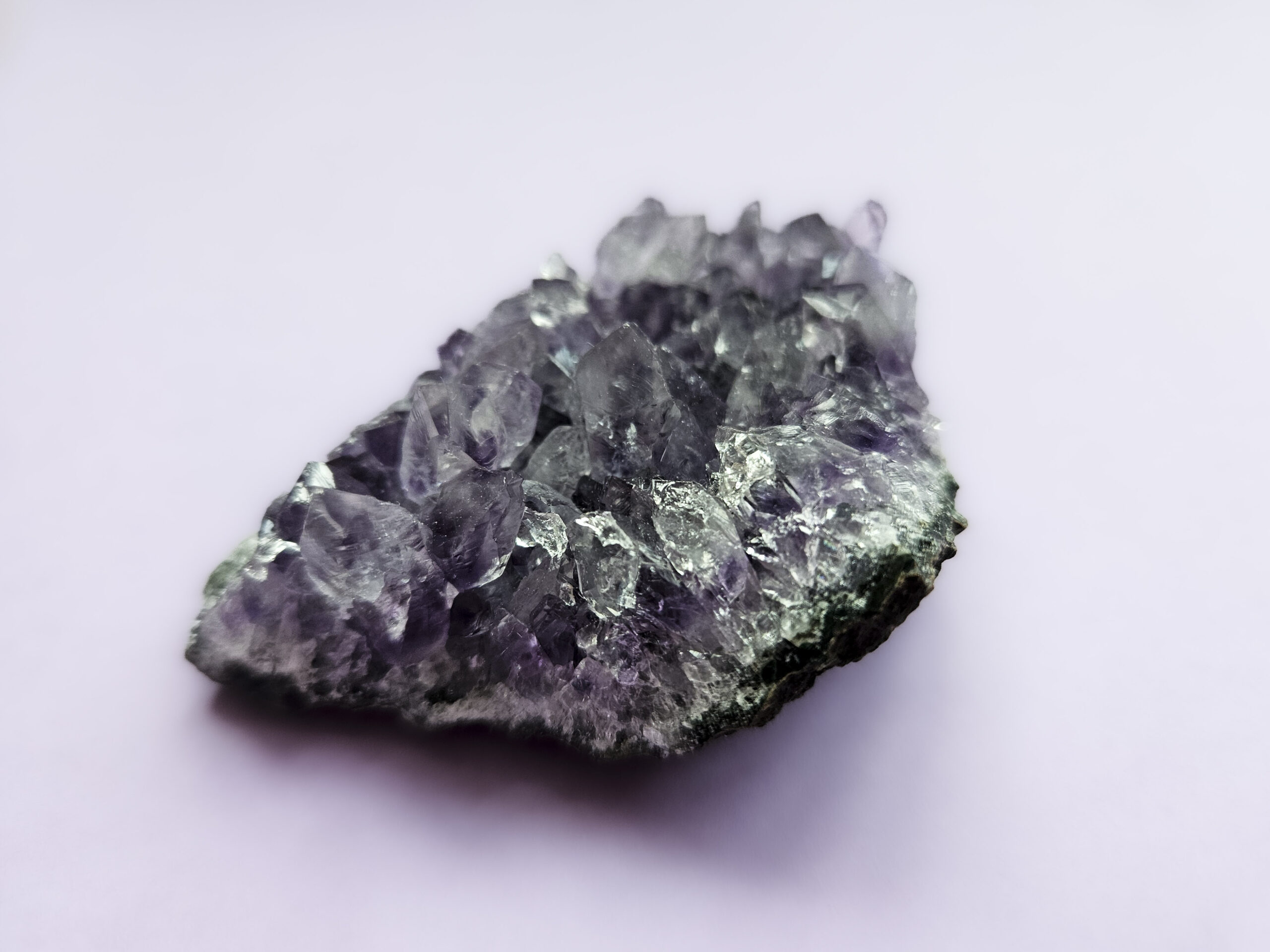 Ametyst klynge, kendt for sine beroligende egenskaber, der fremmer indre ro, åndelig vækst og beskytter mod negative energier. Glimter som en smuk violet stjernehimmel.