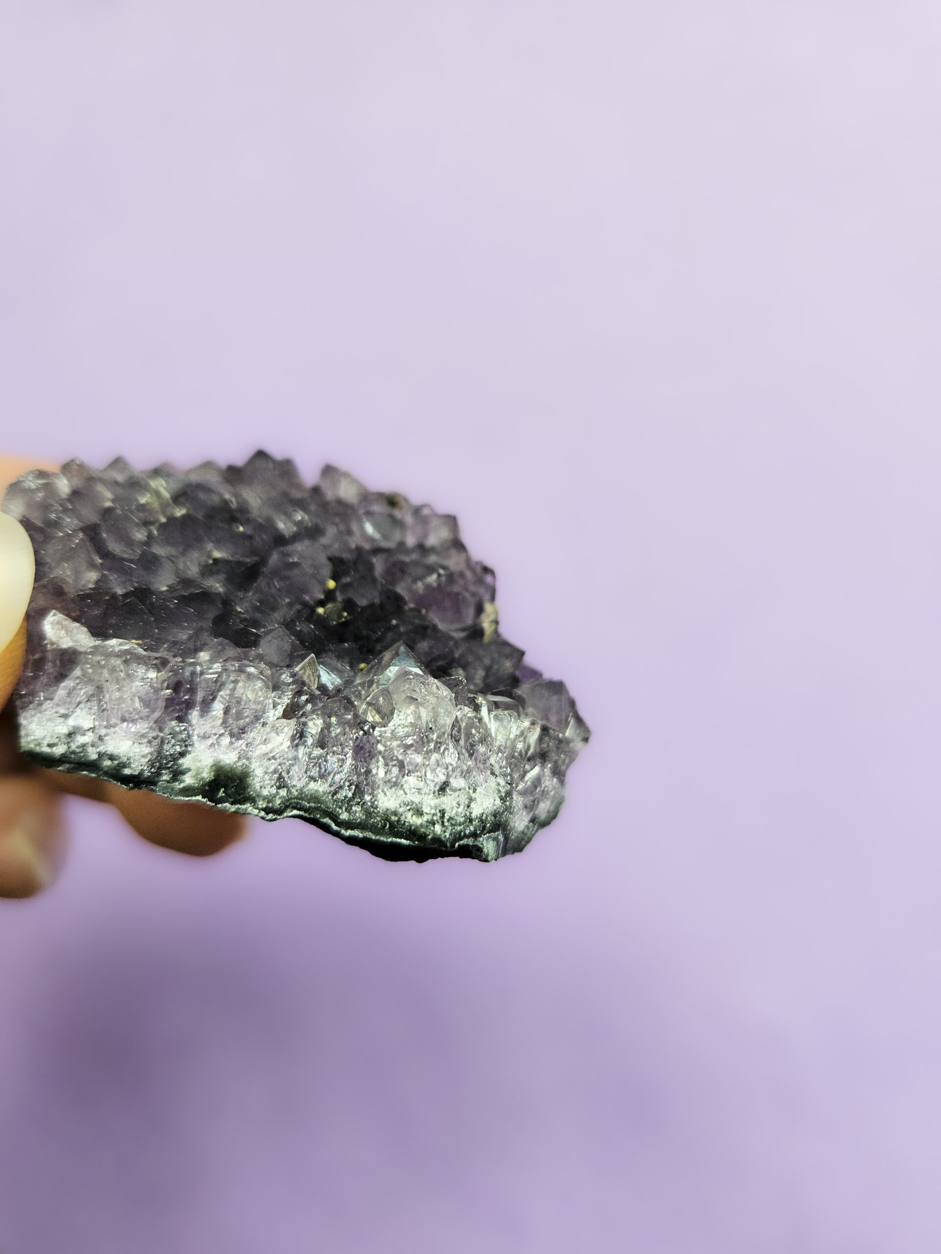 Ametyst klynge, kendt for sine beroligende egenskaber, der fremmer indre ro, åndelig vækst og beskytter mod negative energier. Glimter som en smuk violet stjernehimmel.