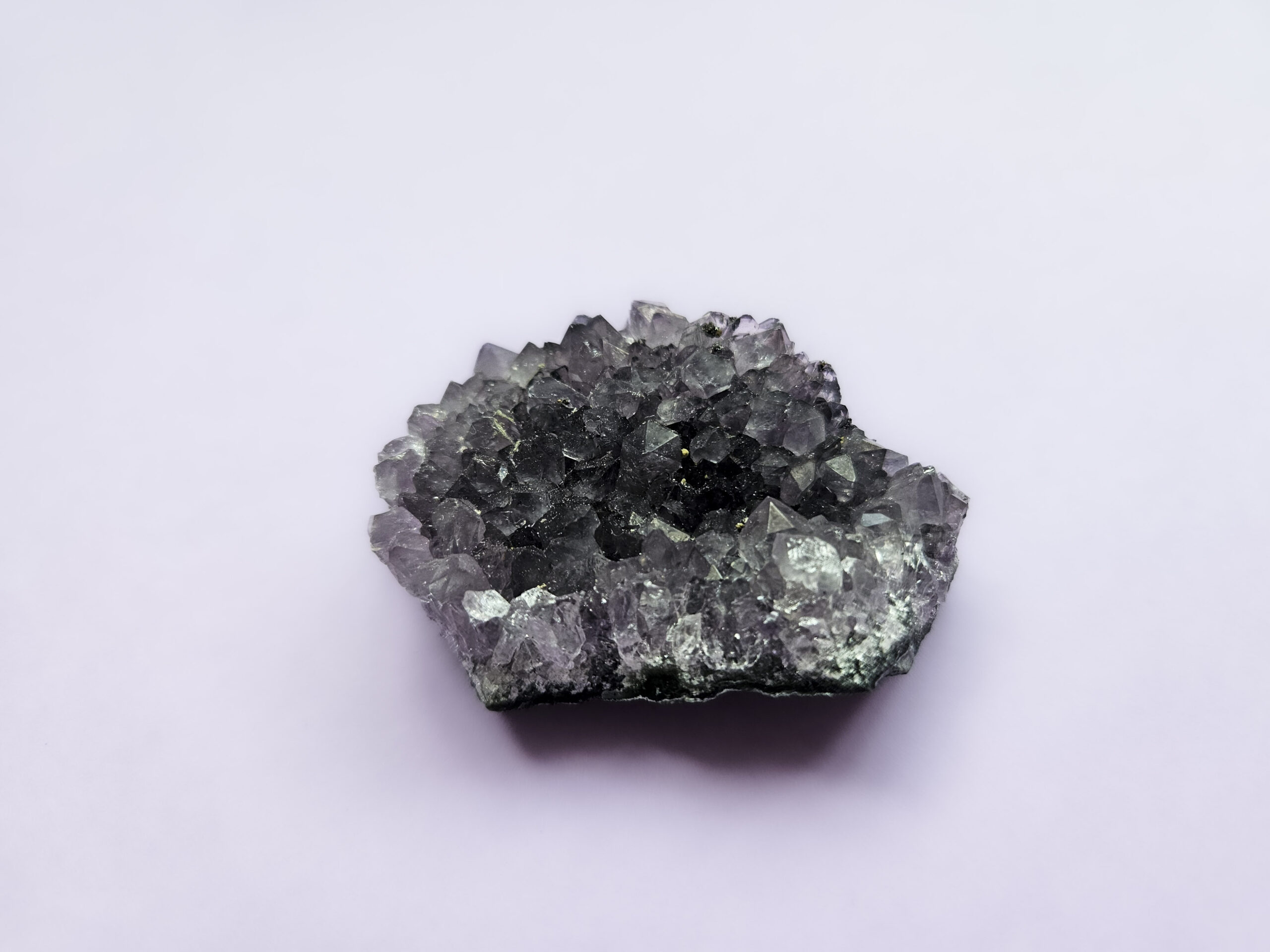 Ametyst klynge, kendt for sine beroligende egenskaber, der fremmer indre ro, åndelig vækst og beskytter mod negative energier. Glimter som en smuk violet stjernehimmel.