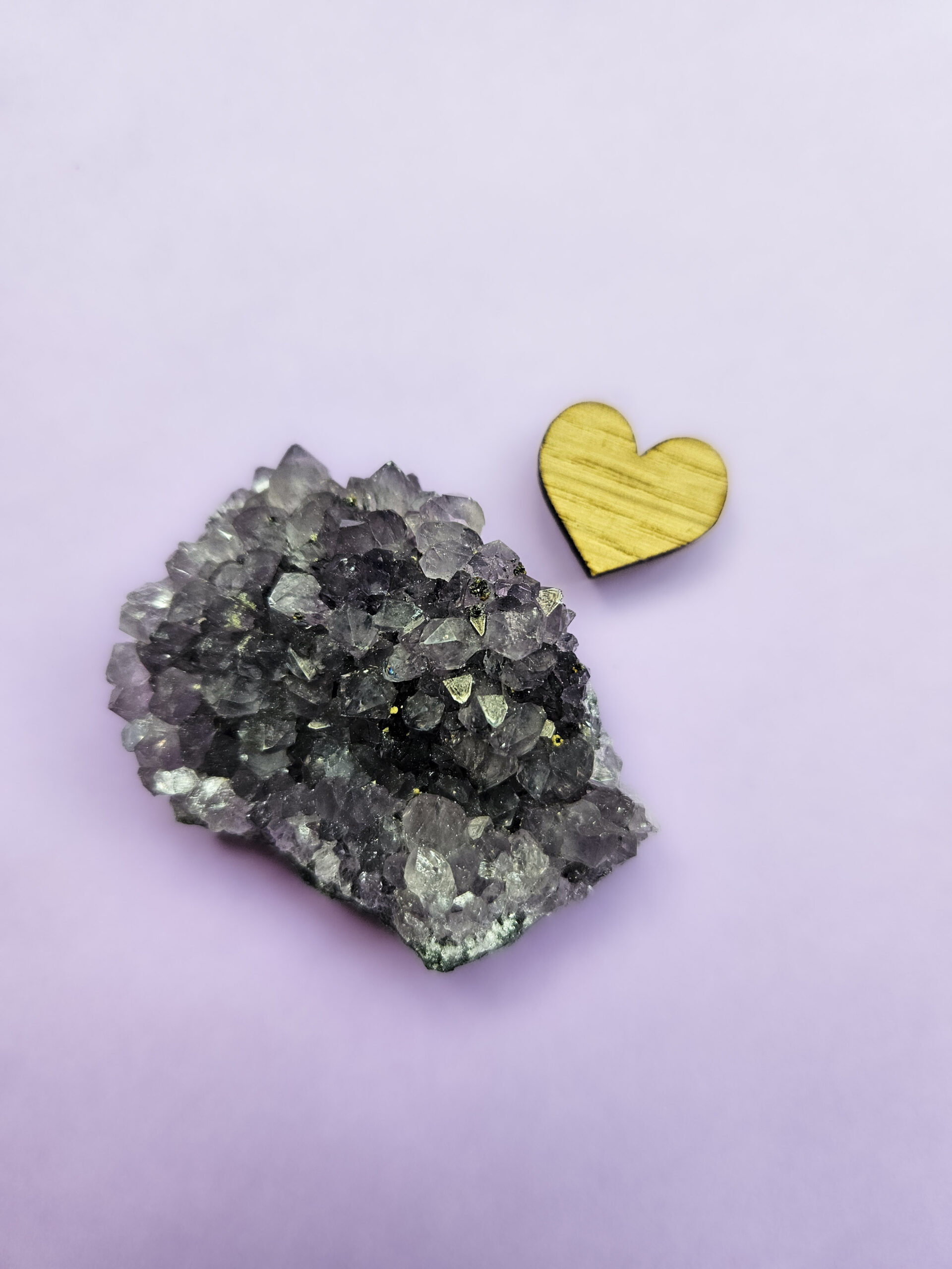 Ametyst klynge, kendt for sine beroligende egenskaber, der fremmer indre ro, åndelig vækst og beskytter mod negative energier. Glimter som en smuk violet stjernehimmel.
