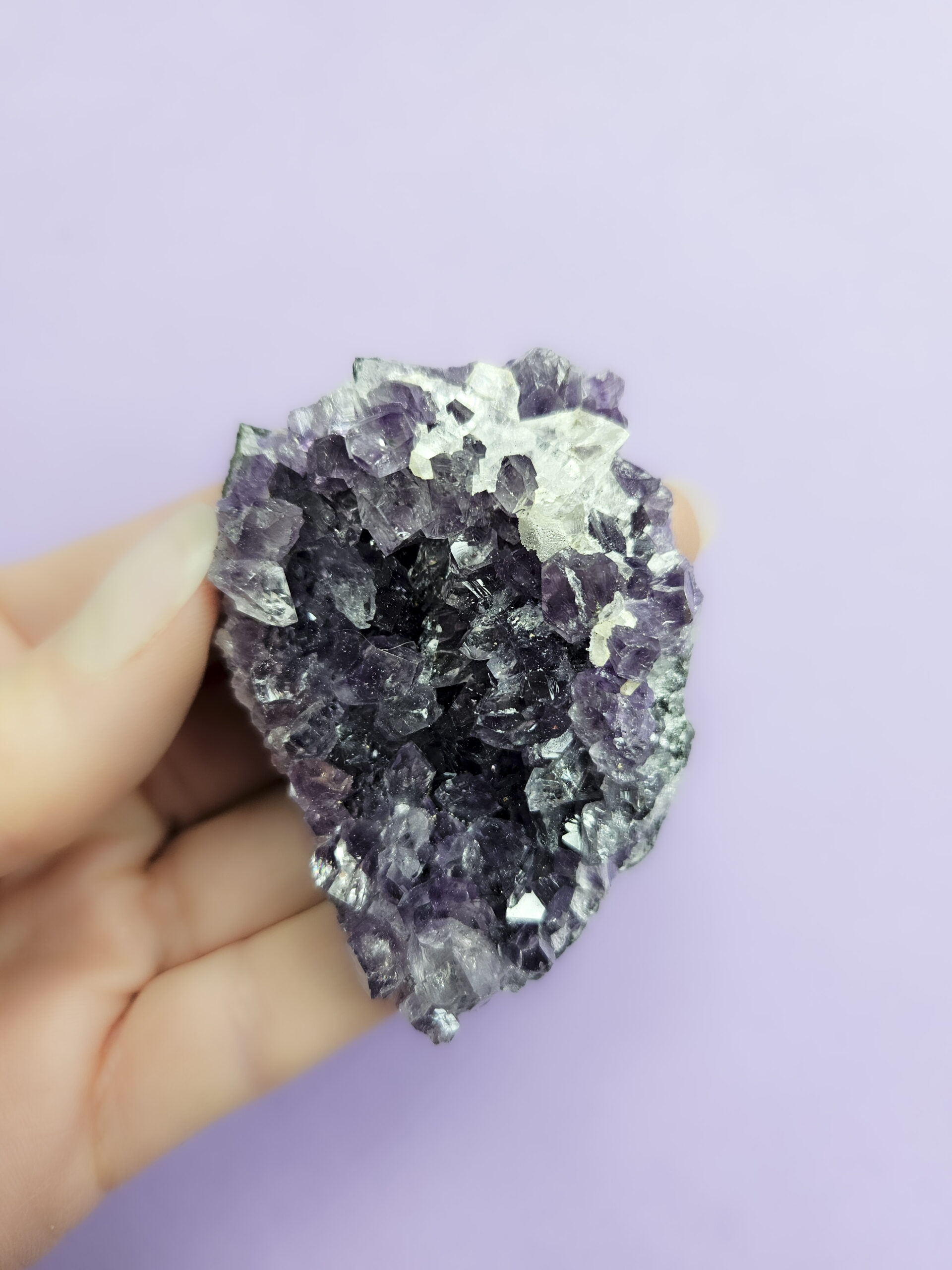 Ametyst klynge, kendt for sine beroligende egenskaber, der fremmer indre ro, åndelig vækst og beskytter mod negative energier. Glimter som en smuk violet stjernehimmel.