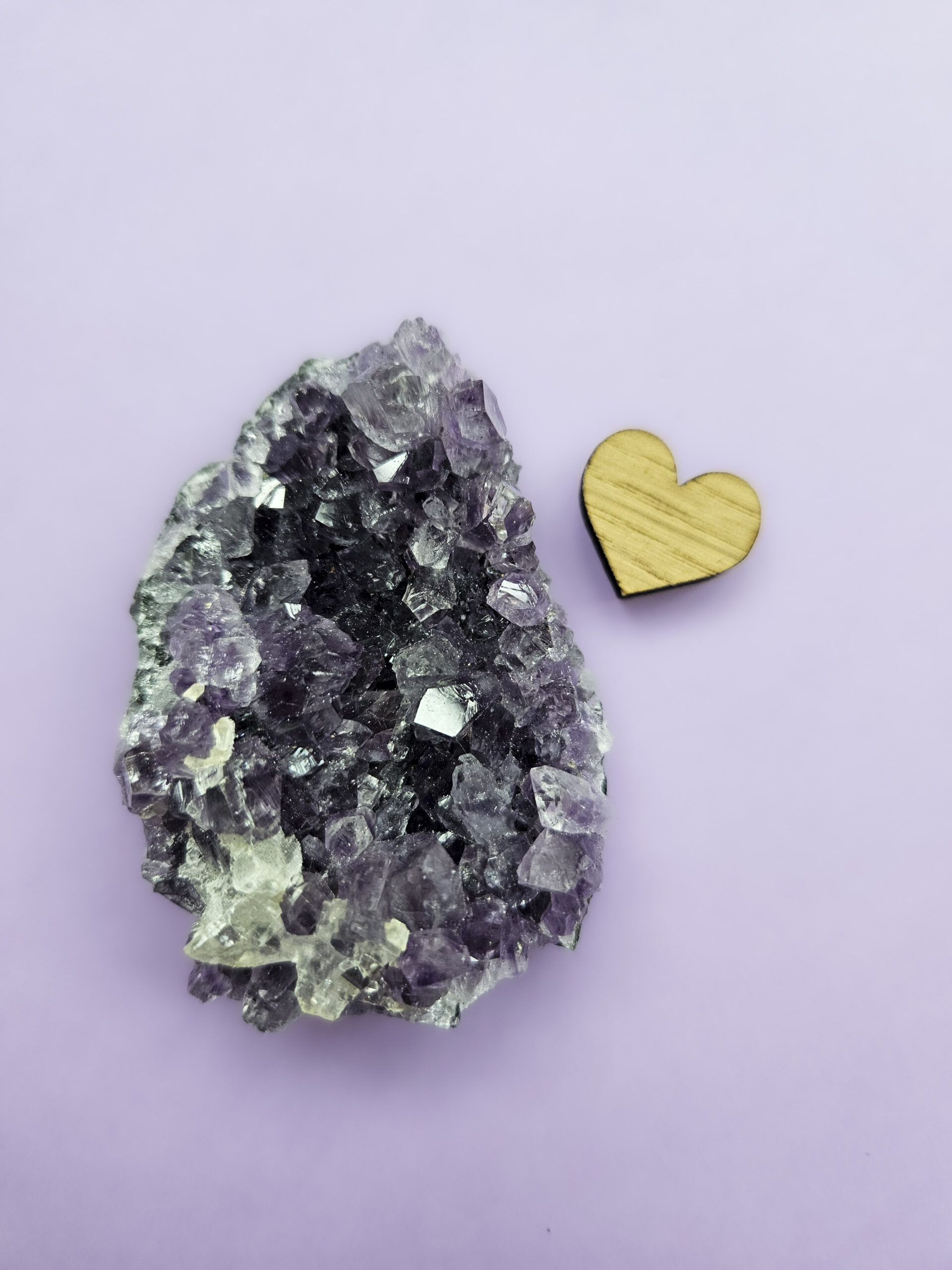 Ametyst klynge, kendt for sine beroligende egenskaber, der fremmer indre ro, åndelig vækst og beskytter mod negative energier. Glimter som en smuk violet stjernehimmel.