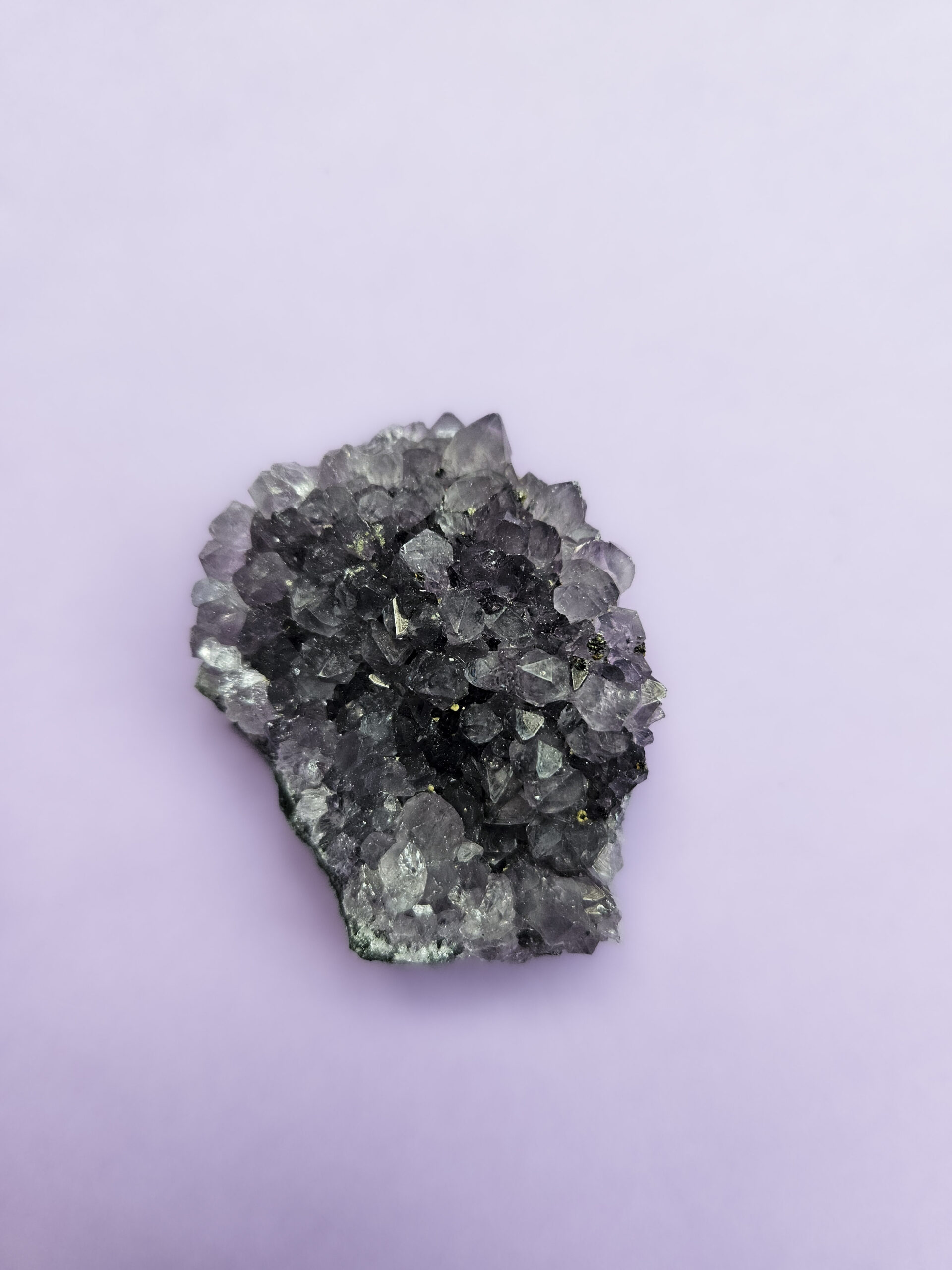 Ametyst klynge, kendt for sine beroligende egenskaber, der fremmer indre ro, åndelig vækst og beskytter mod negative energier. Glimter som en smuk violet stjernehimmel.