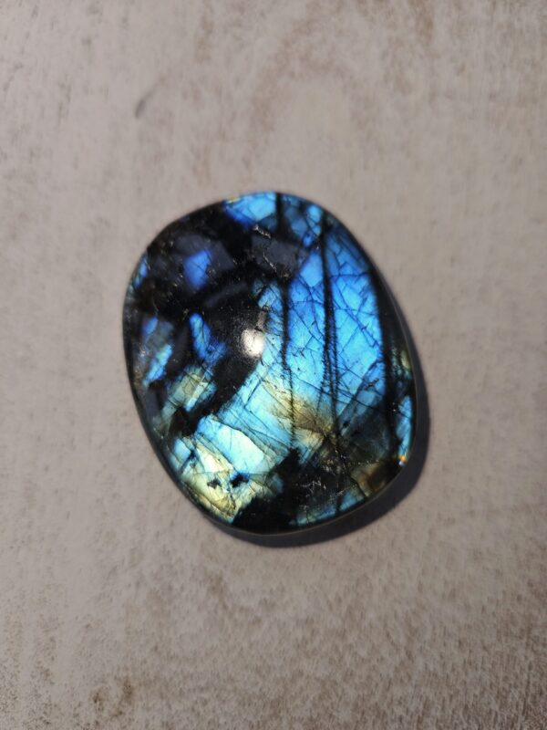 Labradorit palmstone med smukt farvespil i blå og grøn. Denne krystal støtter transformation, beskytter mod negativ energi og fremmer intuition, selvbevidsthed og indre ro. Perfekt til at åbne sindet for nye muligheder.