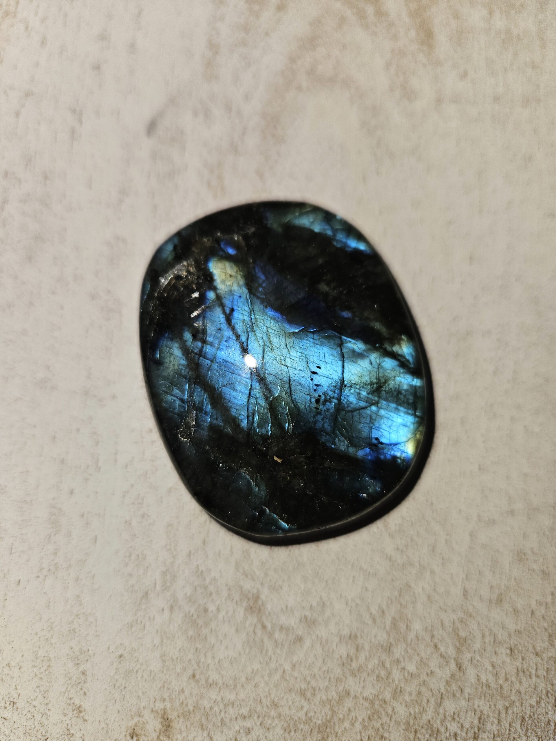 Labradorit palmstone med smukt farvespil i blå og grøn. Denne krystal støtter transformation, beskytter mod negativ energi og fremmer intuition, selvbevidsthed og indre ro. Perfekt til at åbne sindet for nye muligheder.