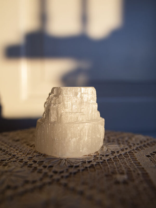 Selenit fyrfadsstage med blødt, rensende lys – perfekt til ro, klarhed og spirituel harmoni.