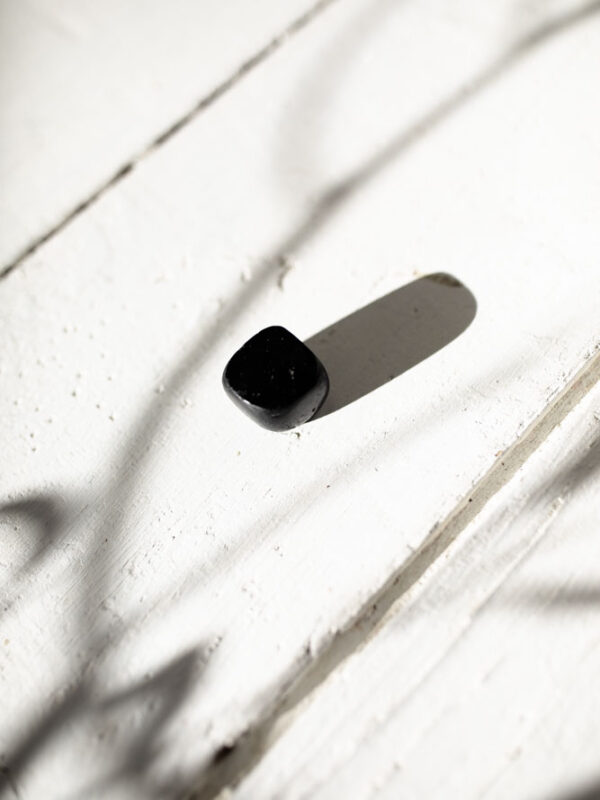 En beskyttende sort turmalin-lommesten, der afskærmer negativ energi og giver jordforbindelse.