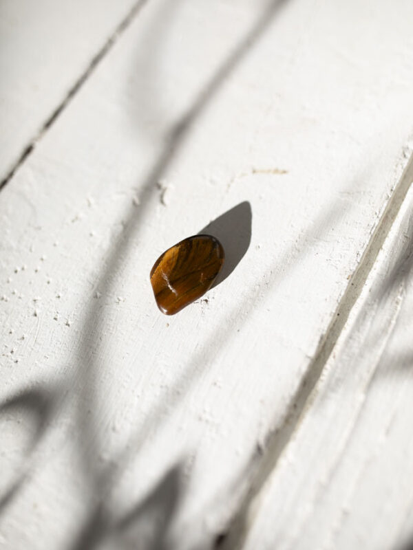 En glødende tigerøje-lommesten, der styrker selvtillid, mod og indre styrke.