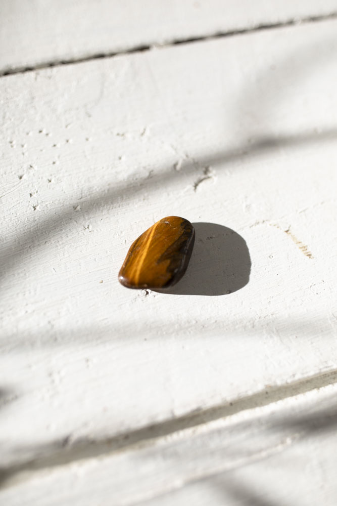 En glødende tigerøje-lommesten, der styrker selvtillid, mod og indre styrke.