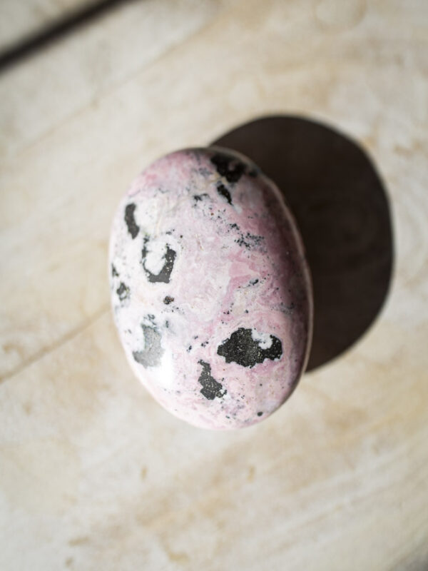 Rhodochrosit palmstone i håndpoleret kvalitet - lyserød krystal med naturlige bånd, ideel til selvkærlighed, healing og meditation.