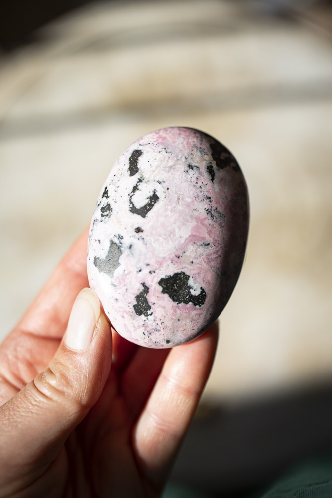Rhodochrosit palmstone i håndpoleret kvalitet - lyserød krystal med naturlige bånd, ideel til selvkærlighed, healing og meditation.
