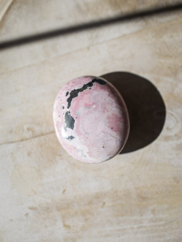 Rhodochrosit palmstone i håndpoleret kvalitet - lyserød krystal med naturlige bånd, ideel til selvkærlighed, healing og meditation.